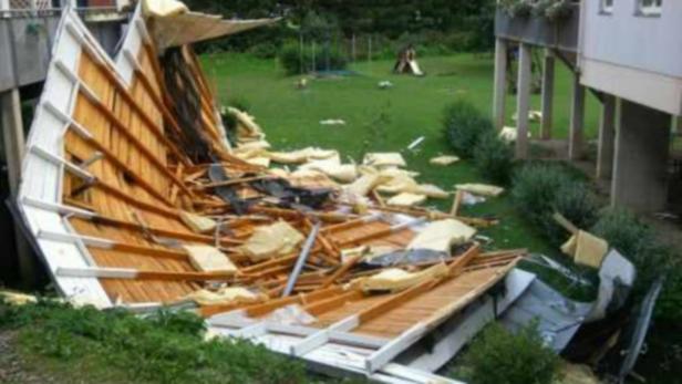 Sturmschaden: Eine 90-km/h-Böe deckte ein Hausdach in Stattegg ab. Ein durch ein Unwetter zerstörtes Carport liegt auf einer Wiese.