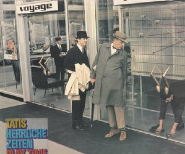 Eine Szene aus Jacques Tatis Film „Playtime“ mit zwei Männern vor einem Schaufenster.