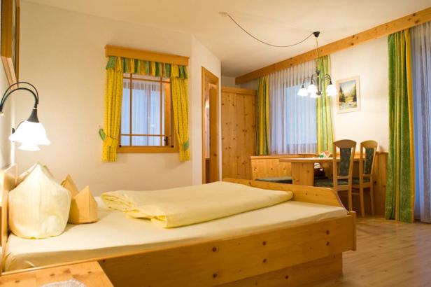 Ein helles, holzvertäfeltes Schlafzimmer mit gelben und grünen Akzenten.