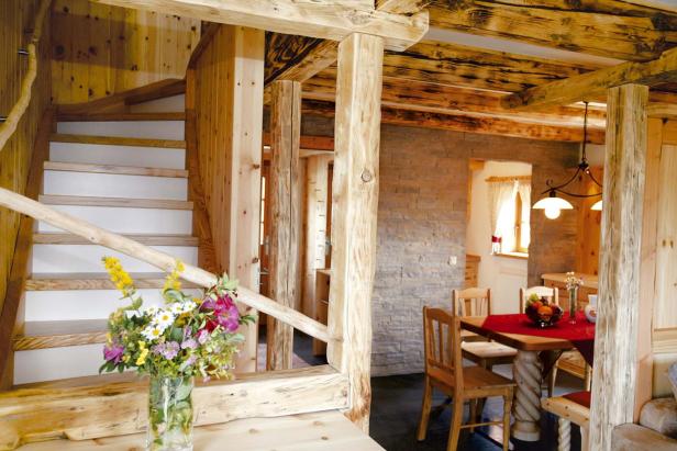 Einrichtung im Landhausstil mit Holztreppe und Esstisch.