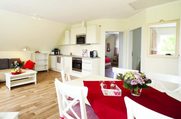 Ein offener Wohnbereich mit Küche und Esstisch in einem hellen Raum.