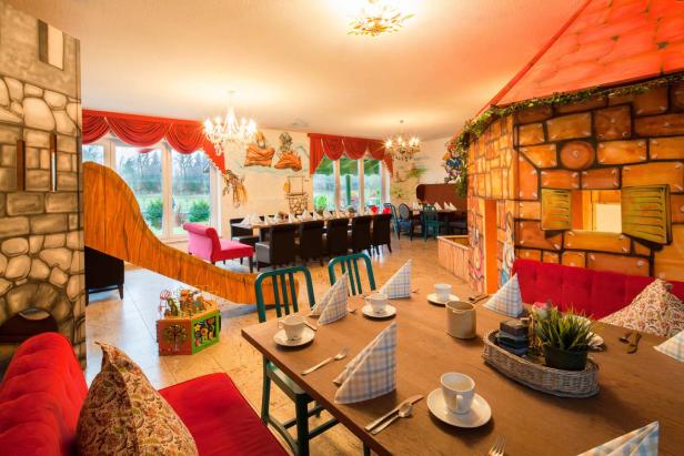 Ein fantasievoll gestalteter Innenraum mit Rutsche und bemalten Wänden für Kinder.