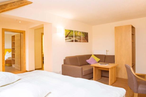 Ein Hotelzimmer mit einem Bett, einer Couch und einem kleinen Tisch.