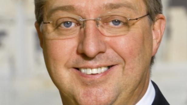Porträt eines lächelnden Mannes mit Brille.