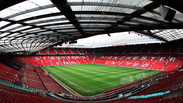 Das Old Trafford Stadion, die Heimspielstätte von Manchester United, mit leeren roten Sitzen.