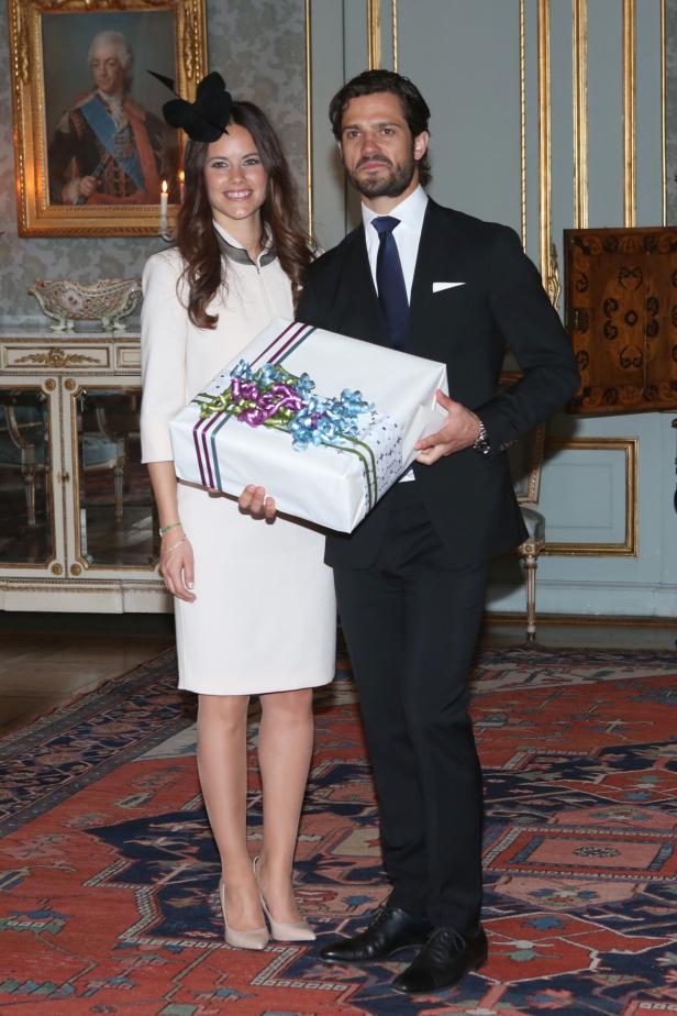 Prinz Carl Philip und Prinzessin Sofia von Schweden mit einem Geschenk.