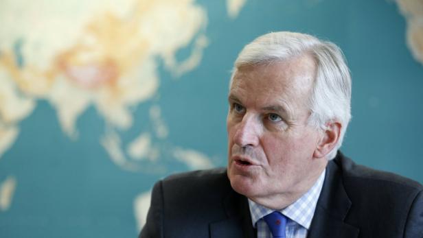 Michel Barnier vor einer Weltkarte während einer Rede.