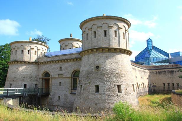 Das Fort Thüngen in Luxemburg mit einem modernen Gebäude im Hintergrund.