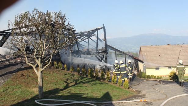 Feuerwehrleute löschen ein abgebranntes Gebäude.