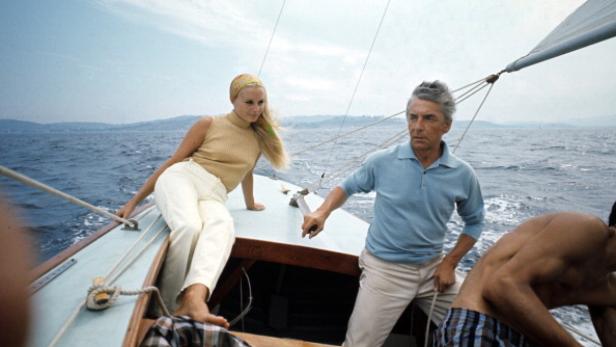 Sie begegneten einander auf einer Yacht, 1958 wurde Eliette Karajans dritte Frau Eine Frau und zwei Männer segeln auf einer Yacht auf dem Meer.