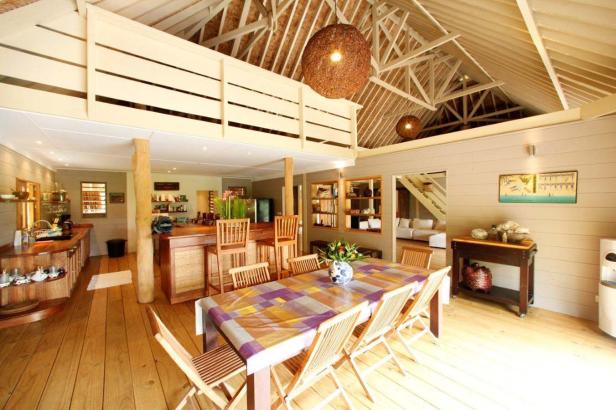 Ein offener Wohnbereich mit Holzboden, hohen Decken und einer Küchentheke.