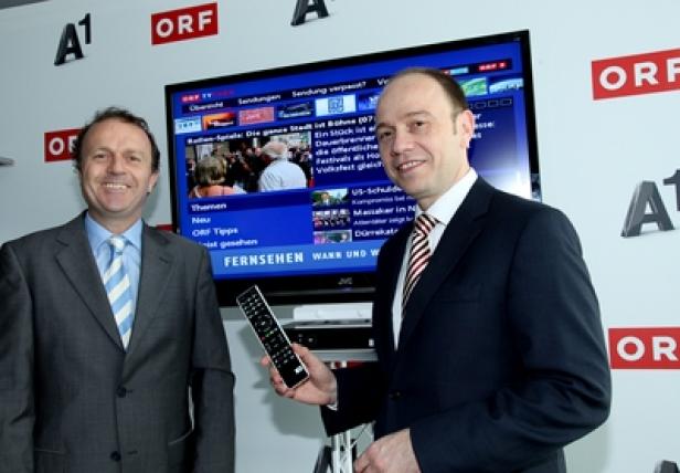 European Promotional Products Association - Grüner Trend Zwei Männer stehen vor einem Fernseher mit dem ORF-Logo und halten eine Fernbedienung.