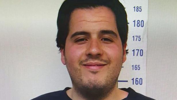 Ein Mann steht vor einer Wand mit Größenangaben.