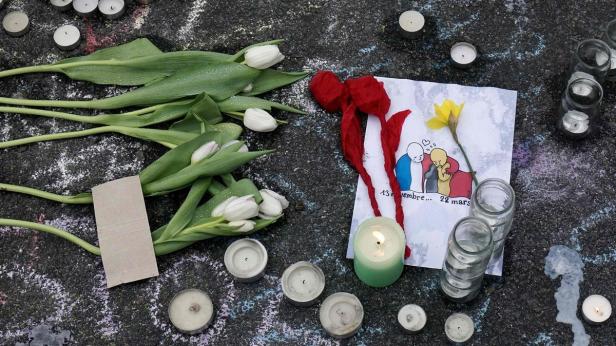 Blumen, Kerzen und eine Zeichnung erinnern an die Terroranschläge vom 13. November und 22. März.