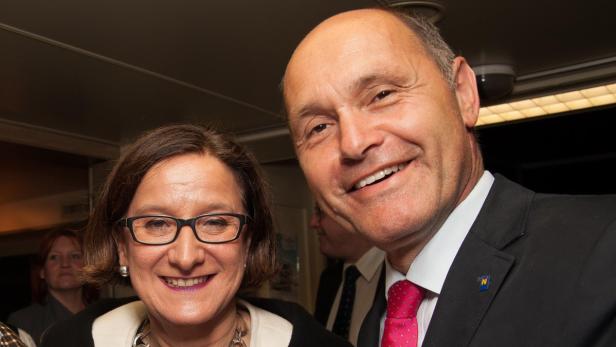 Ein lächelnder Mann im Anzug mit einer Frau mit Brille.
