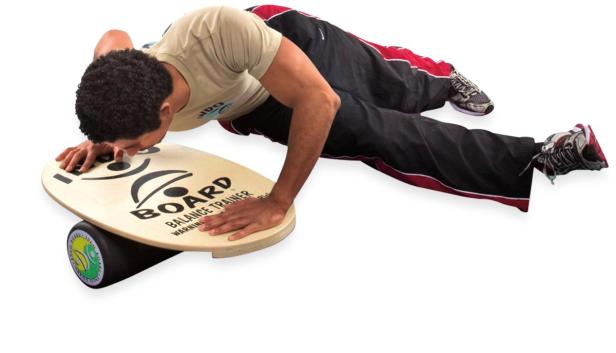 Ein Mann macht Liegestütze auf einem Balance Board.