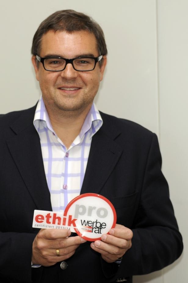 Ein Mann im Anzug hält Schilder mit der Aufschrift „Ethik zertifiziert 2013/14“ und „pro werberat“.