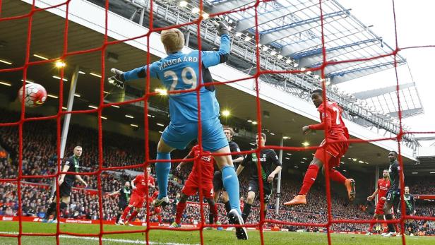 Ein Fußballtorwart versucht, einen Ball während eines Fußballspiels zu halten.