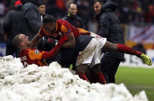 Fußballspieler feiern ein Tor im Schnee.