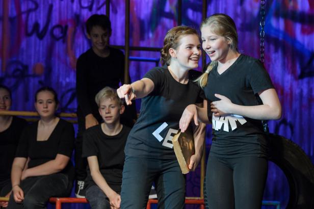 Jugendliche bei einer Theateraufführung auf der Bühne.