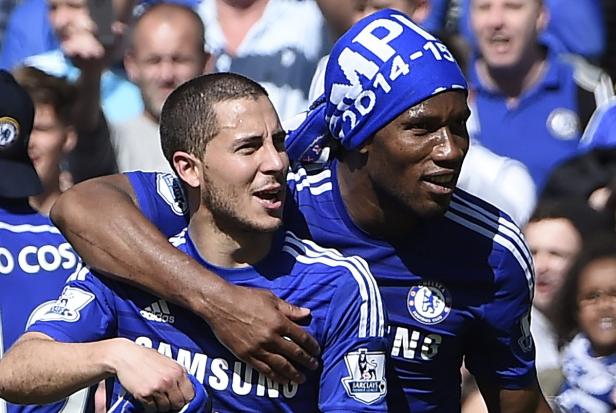 Eden Hazard und Didier Drogba umarmen sich in ihren Chelsea-Trikots.