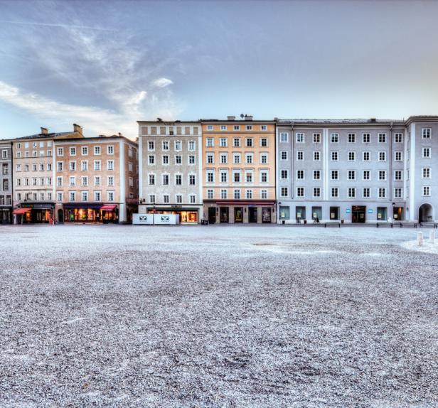 Ein leerer Platz mit historischen Gebäuden im Hintergrund.