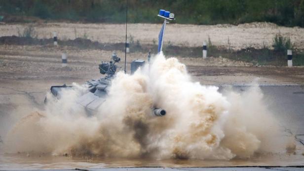 Ein Panzer durchfährt ein Gewässer, wobei eine große Wasserfontäne entsteht.