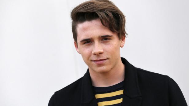 Ein Porträt von Brooklyn Beckham vor einem hellen Hintergrund.
