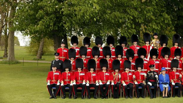 Königin Elisabeth II. posiert mit den Gardesoldaten für ein Gruppenfoto.