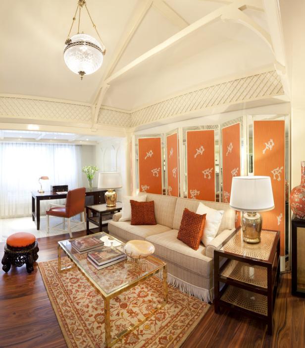 Ein Wohnzimmer mit einem Sofa, einem Couchtisch und einem Schreibtisch im Hintergrund.