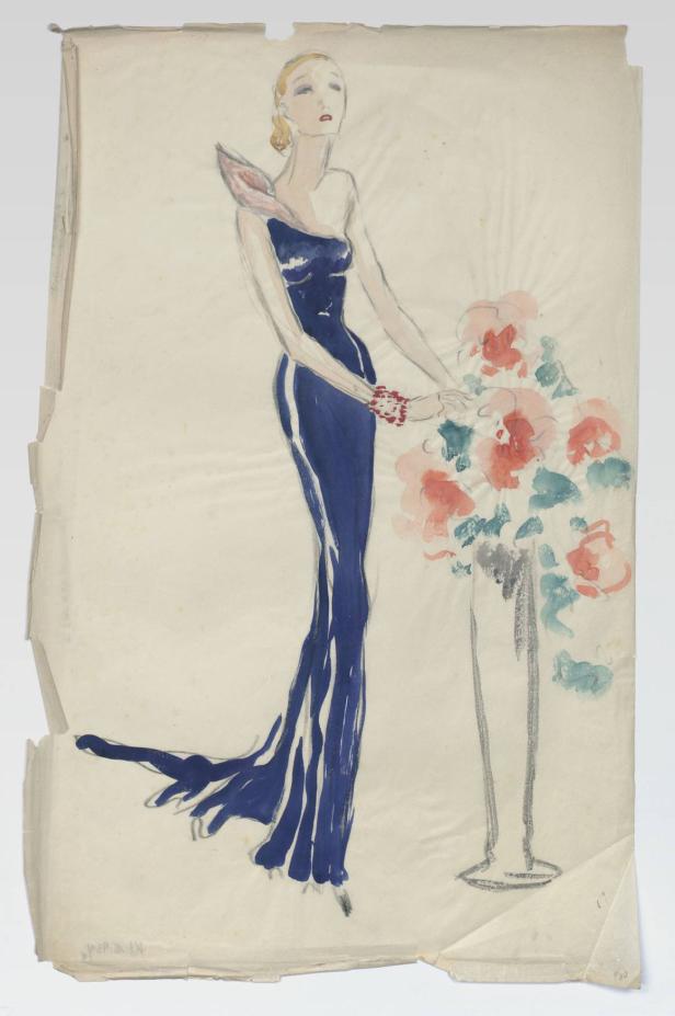 Eine Frau in einem blauen Kleid steht neben einem Blumenstrauß.