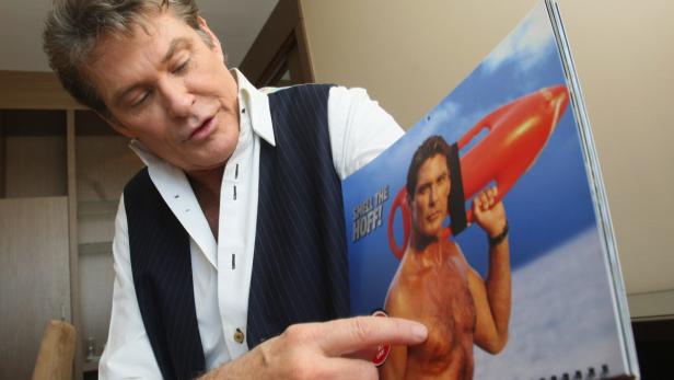 David Hasselhoff präsentiert einen Kalender mit einem Bild von sich als Rettungsschwimmer.