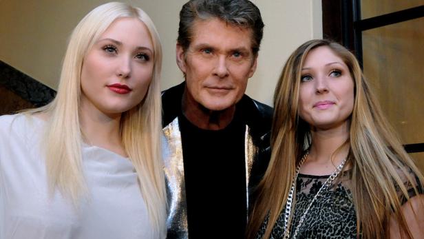 David Hasselhoff posiert mit zwei jungen Frauen für ein Foto.