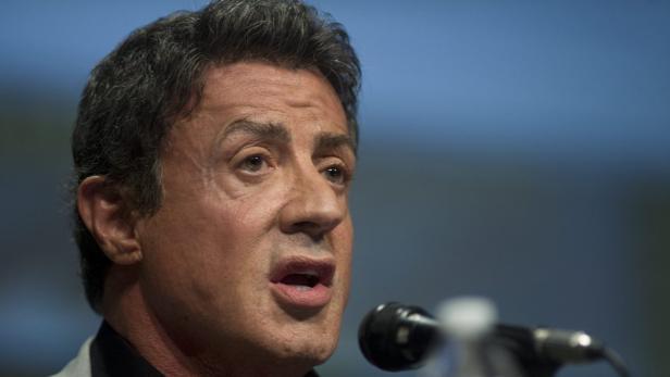 Sylvester Stallone spricht in ein Mikrofon.