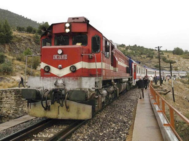 Eine rote Diesellokomotive der türkischen Staatsbahn steht auf einem Bahnhof.
