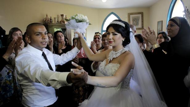 Ein Brautpaar tanzt auf seiner Hochzeit, umgeben von applaudierenden Gästen.