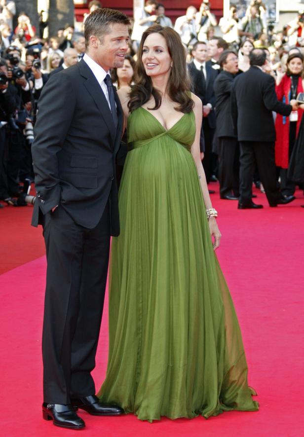 Brad Pitt und Angelina Jolie auf dem roten Teppich, Jolie trägt ein grünes Kleid und ist schwanger.