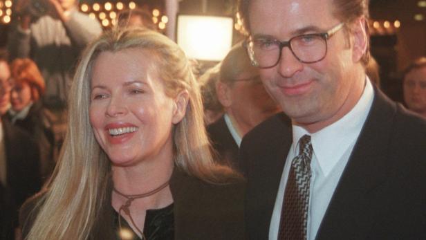 Kim Basinger und Alec Baldwin lächeln auf einer Veranstaltung in die Kamera.