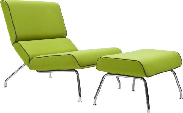 Ein grüner Sessel mit Fußhocker auf einem weißen Hintergrund.