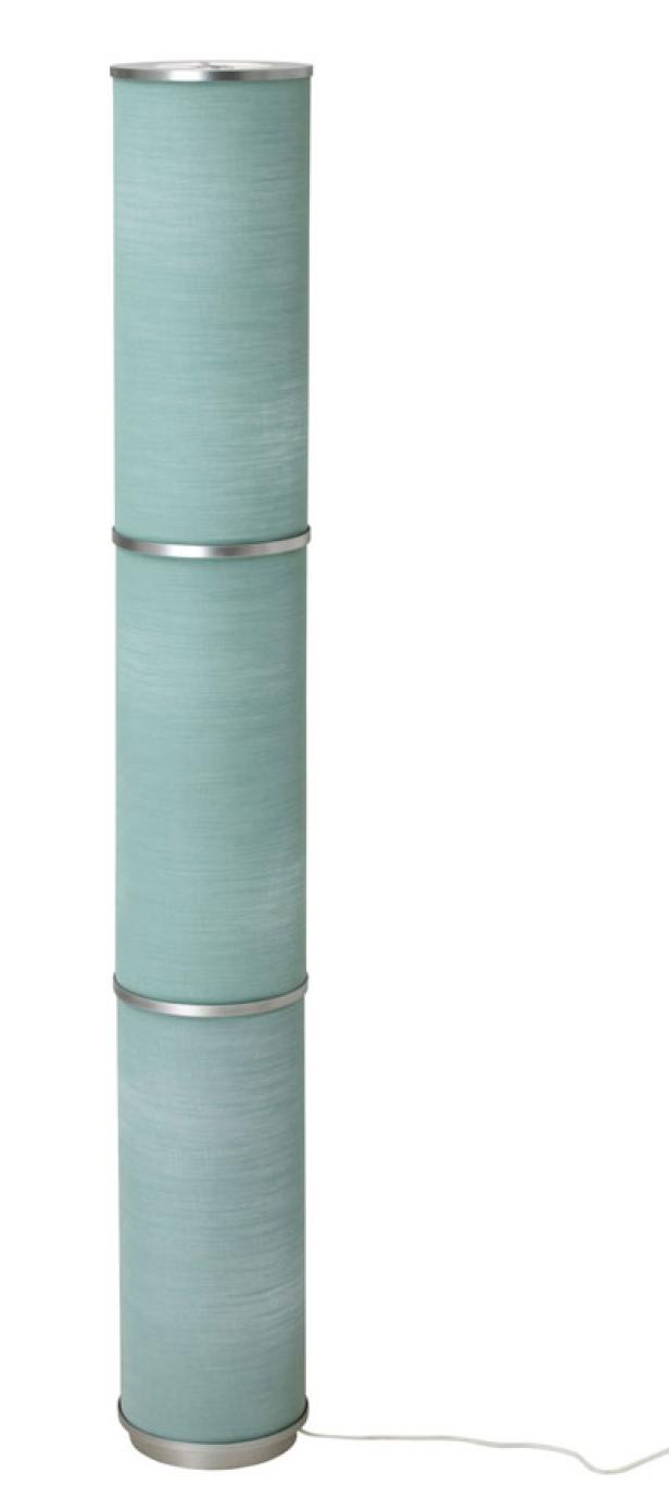 Eine Stehlampe mit einem hellblauen, zylindrischen Lampenschirm aus Stoff.