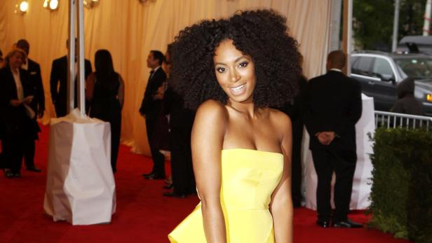 Solange Knowles in einem gelben Kleid auf einem roten Teppich.