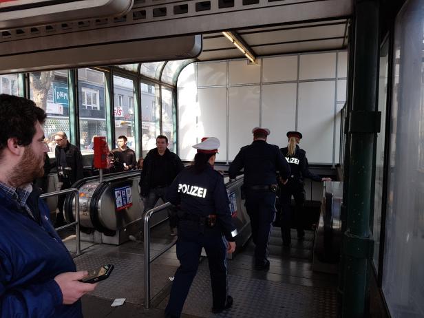 Wiener Polizisten betreten eine U-Bahn-Station über eine Rolltreppe.