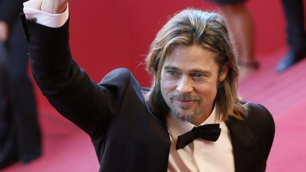 Brad Pitt auf einem roten Teppich, gekleidet in einem schwarzen Anzug mit Fliege.