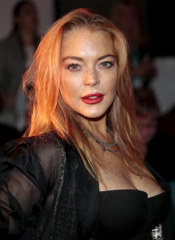 Ein Porträt von Lindsay Lohan mit roten Lippen und einer schwarzen Jacke.