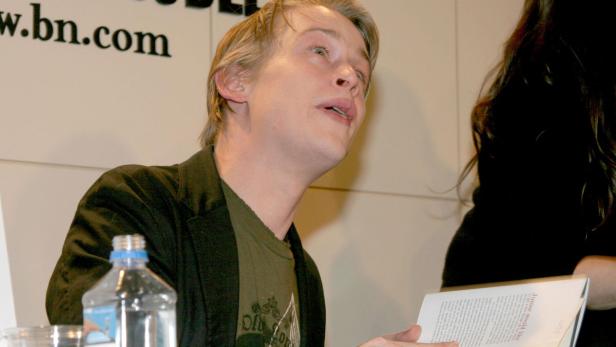 Kieran Culkin liest aus einem Buch bei einer Veranstaltung.