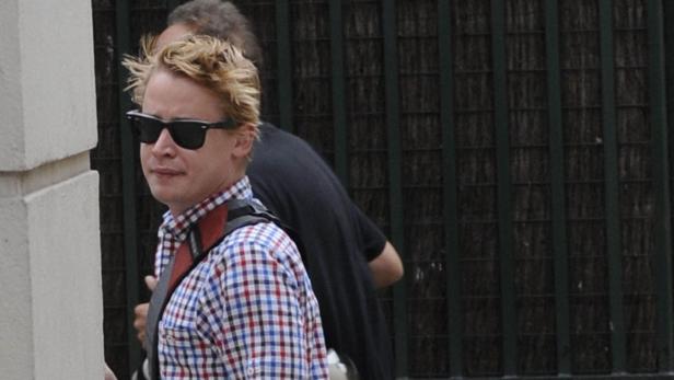 Macaulay Culkin mit Sonnenbrille und kariertem Hemd.