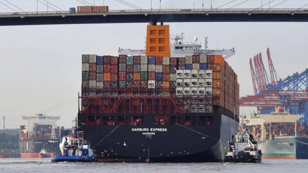 Das Containerschiff „Hamburg Express“ wird von Schleppern auf der Elbe begleitet.