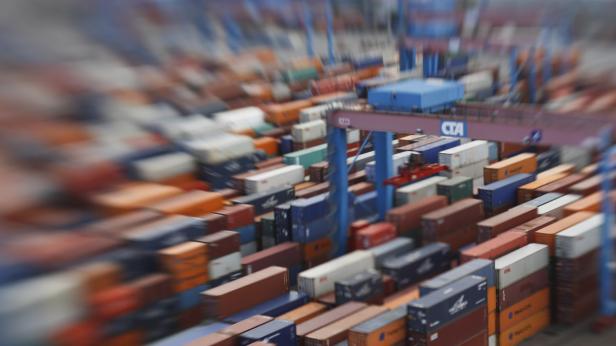 Ein Kran bewegt Container in einem Lagerbereich.
