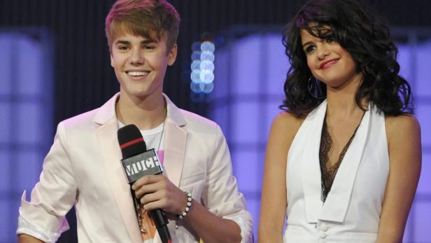 Justin Bieber und Selena Gomez posieren auf einer Veranstaltung.