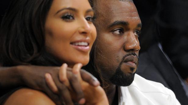 Kim Kardashian und Kanye West sitzen nebeneinander.